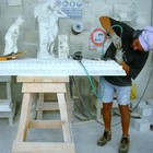 un ornatista cesella il frontone di un caminetto in marmo